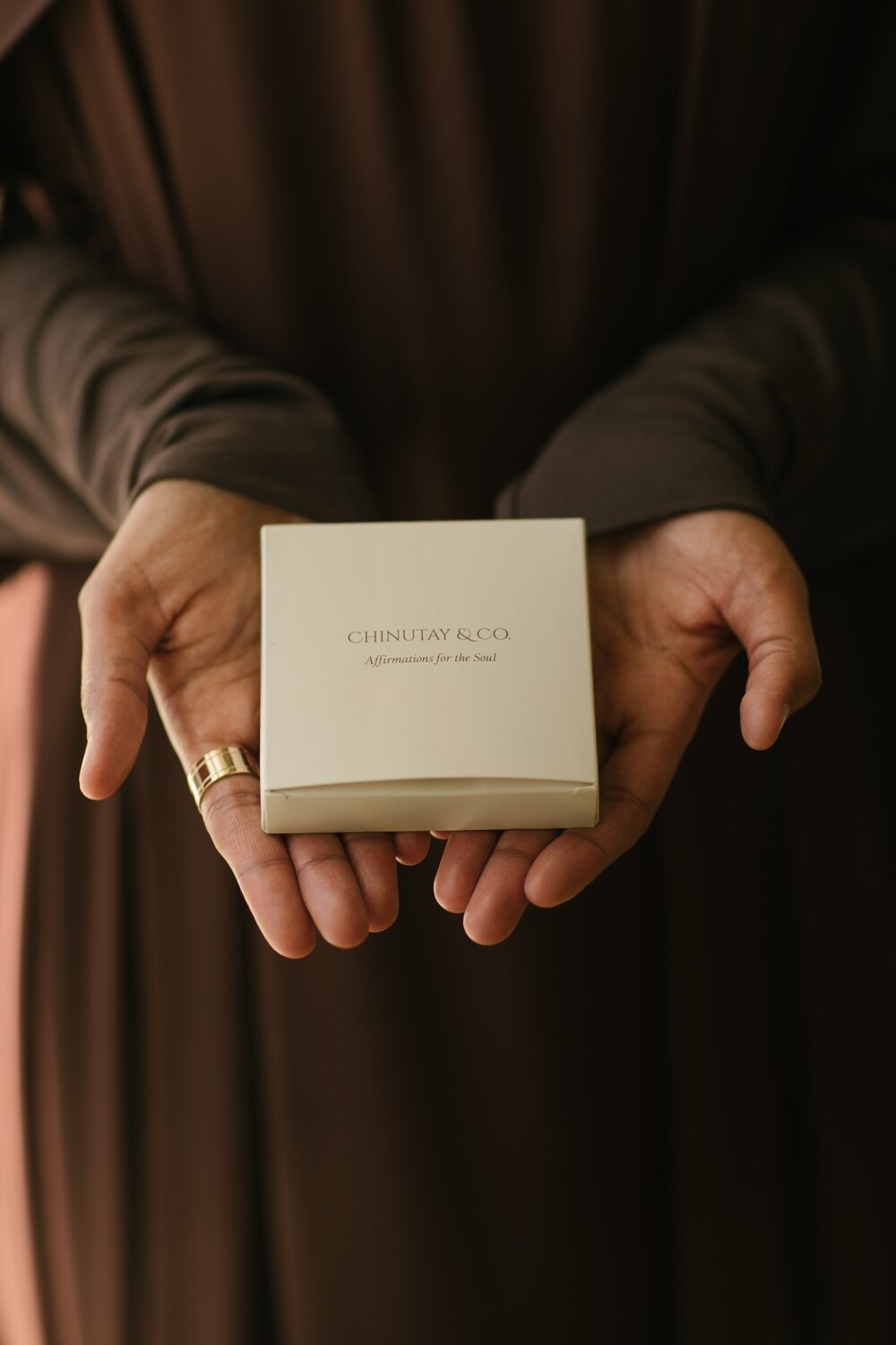 A person holding a box of Chinutay & Co self affirmation cards.